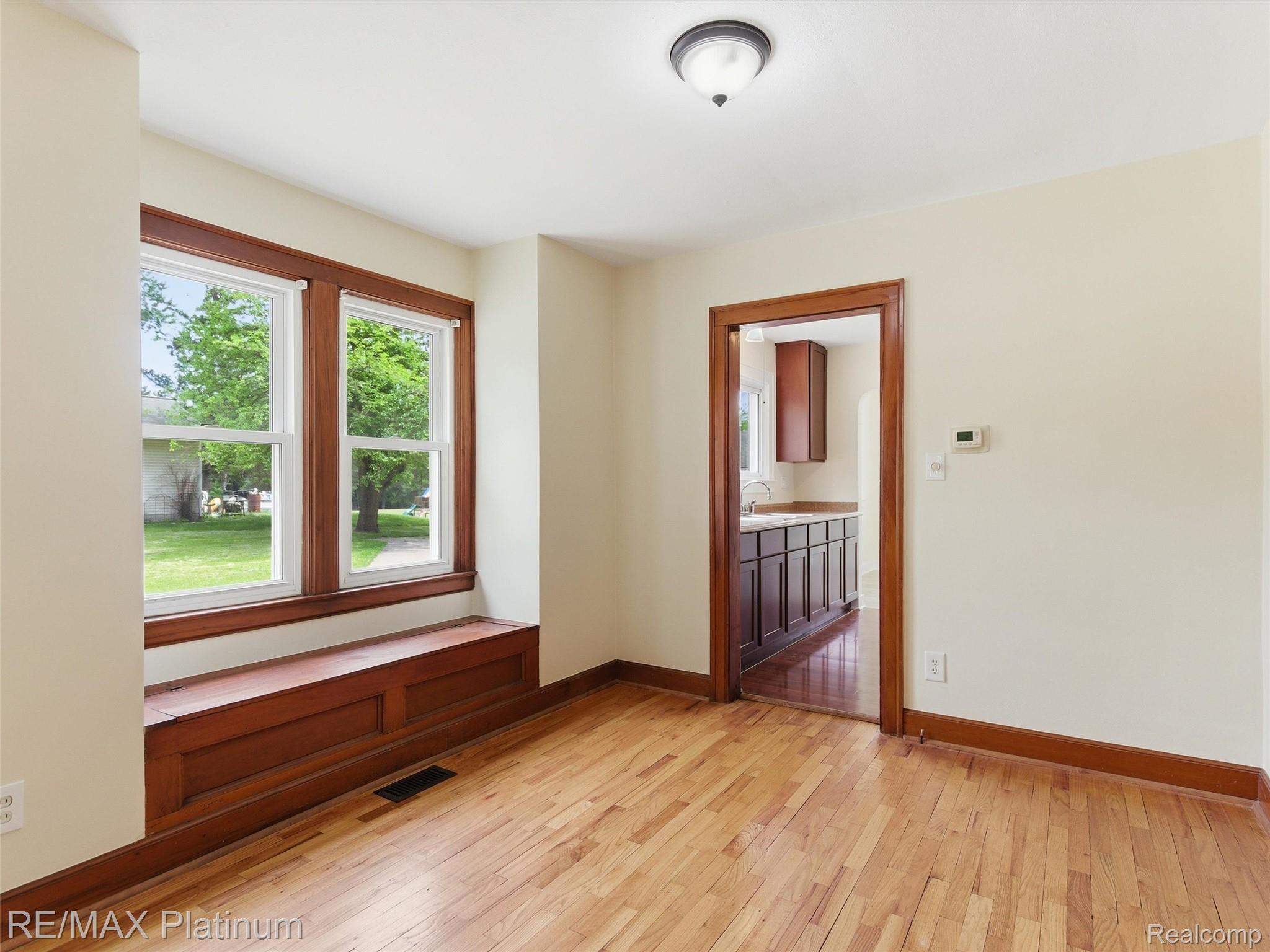 6335 Silver Lake Road Linden, MI 48451 - Photo 11 of 61 Room featuring wood-finish flooring, a built-in window bench, white walls, and a semi-flush mount ceiling light