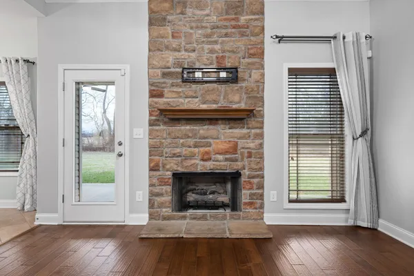 a living room with a fireplace and wooden floor
