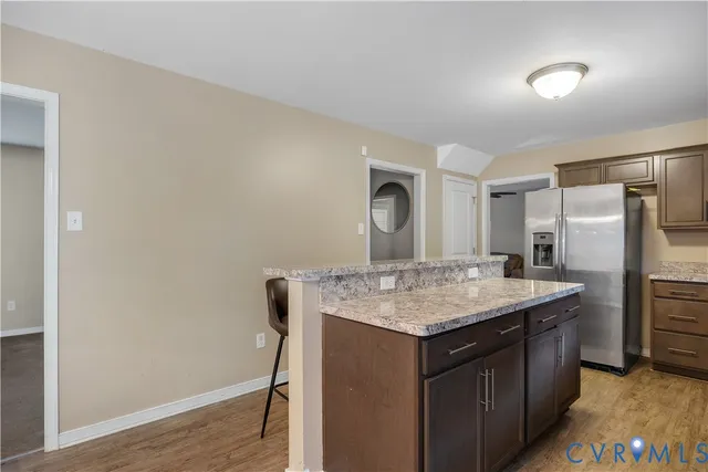 a kitchen with a stove a refrigerator and wooden floor