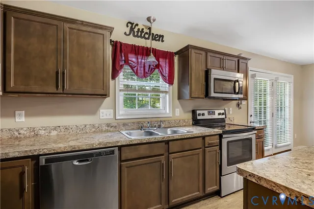 a kitchen with stainless steel appliances granite countertop a sink stove and microwave