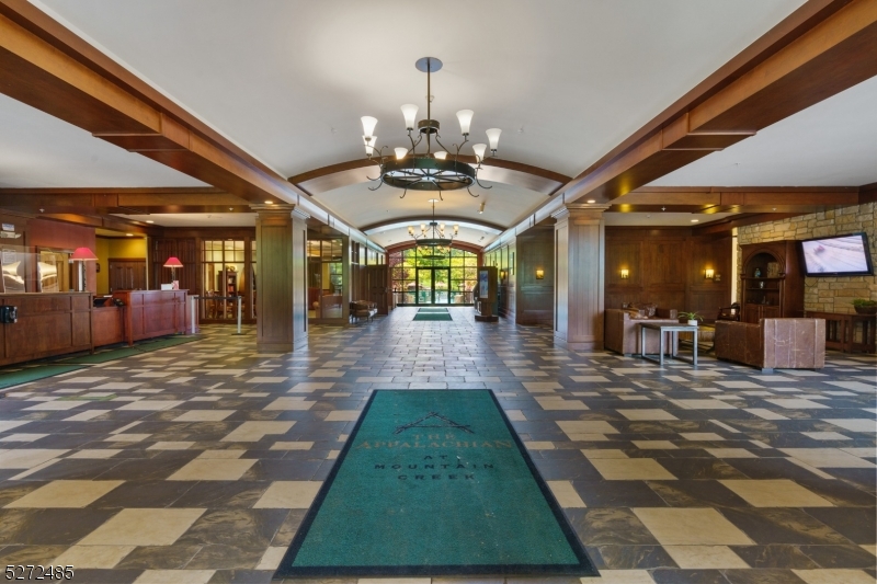 a view of lobby with a rug floor and a chandelier