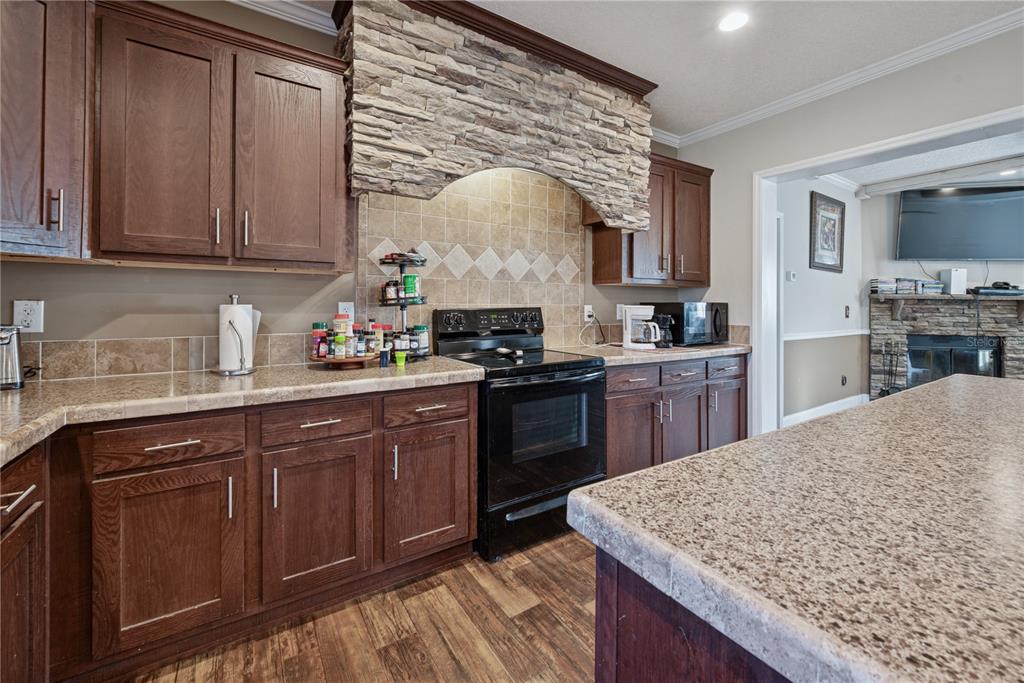 129 Perry Road, Unit 1 Hawthorne, FL 32640 - Photo 16 of 58 a kitchen with stainless steel appliances granite countertop wooden cabinets a stove top oven a sink and dishwasher