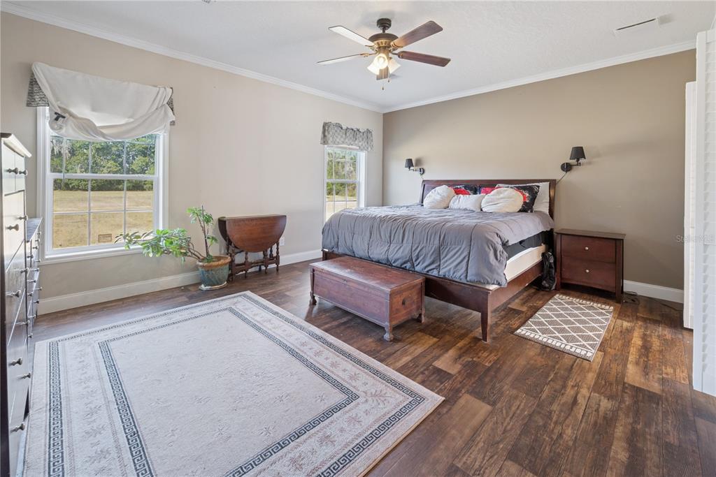 129 Perry Road, Unit 1 Hawthorne, FL 32640 - Photo 29 of 58 a spacious bedroom with a bed a couch and a window with wooden floor