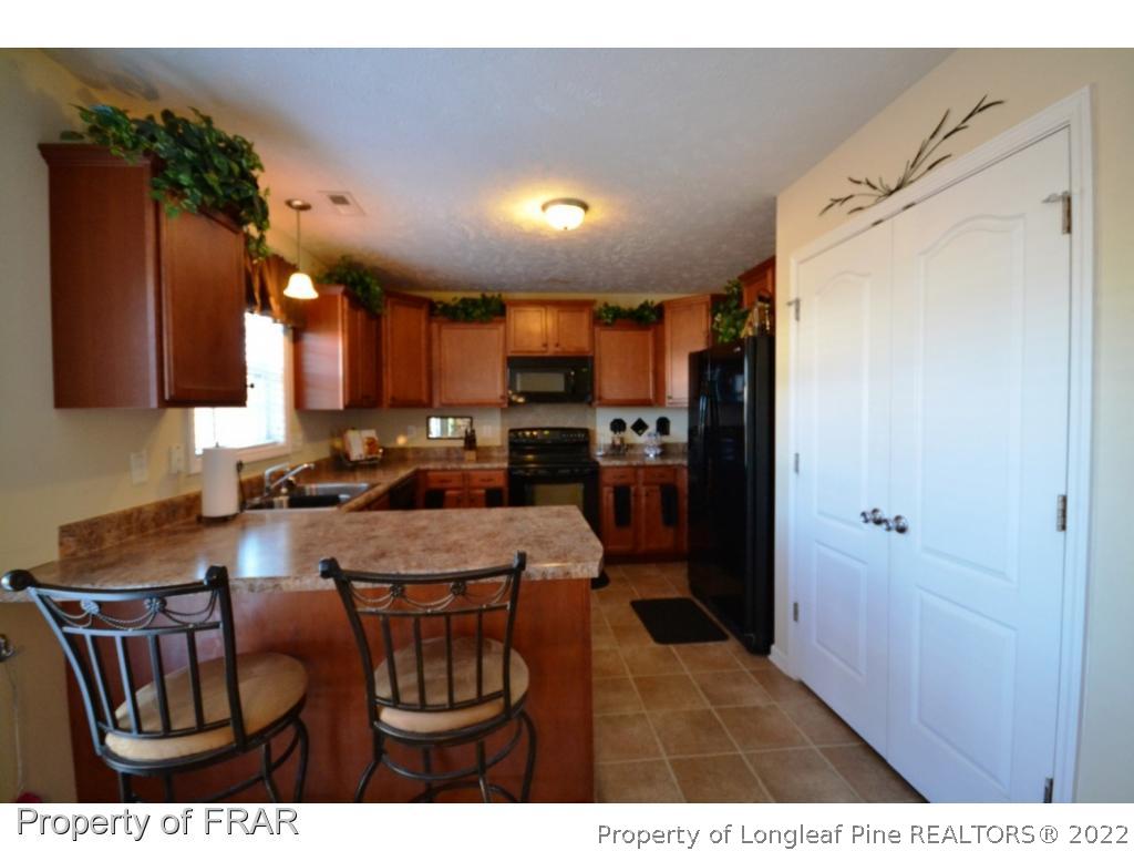 645 Cape Fear Road Raeford, NC 28376 - Photo 11 of 24 a kitchen with refrigerator cabinets and furniture