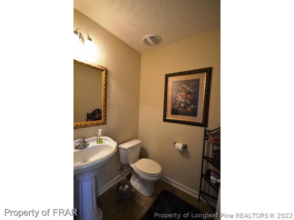 645 Cape Fear Road Raeford, NC 28376 - Photo 14 of 24 a bathroom with a toilet a sink and mirror