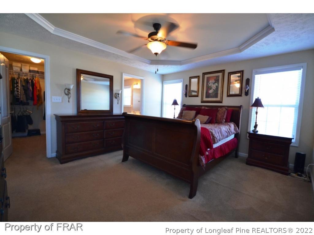 645 Cape Fear Road Raeford, NC 28376 - Photo 19 of 24 a spacious bedroom with a bed and a chandelier