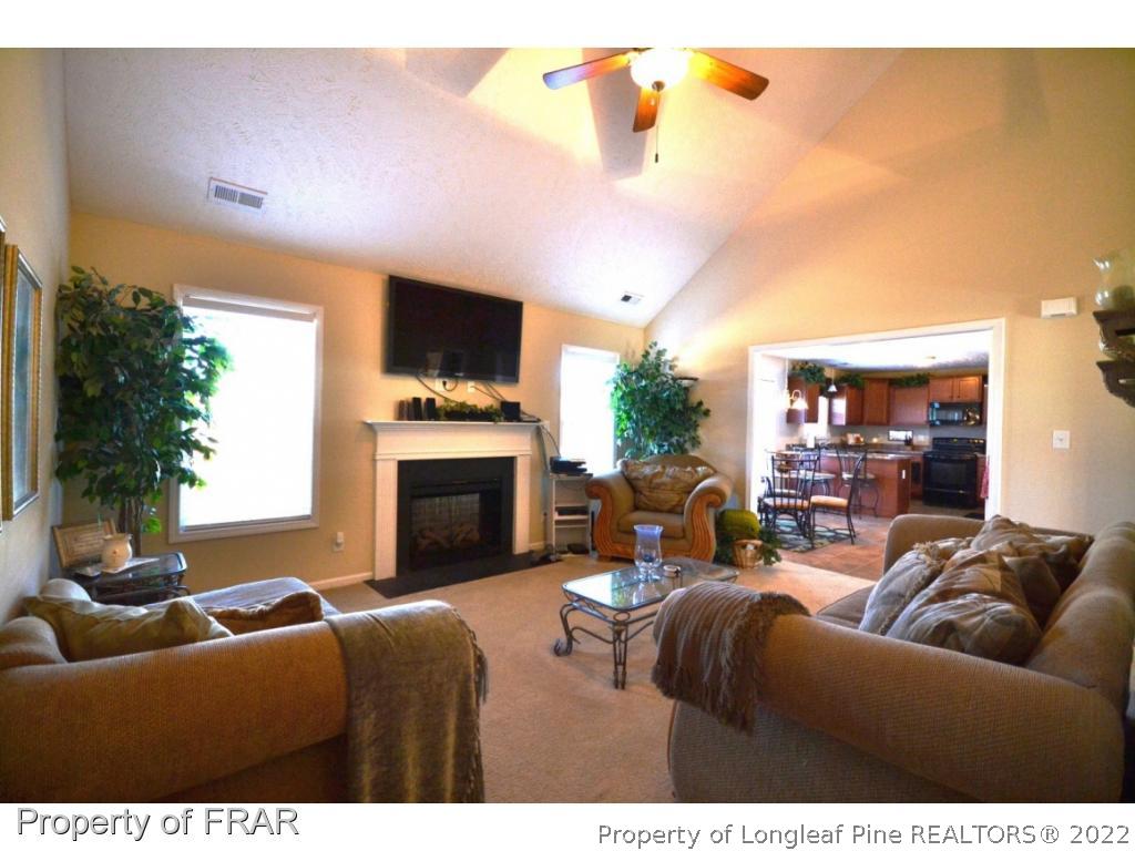 645 Cape Fear Road Raeford, NC 28376 - Photo 5 of 24 a living room with furniture a fireplace and a flat screen tv
