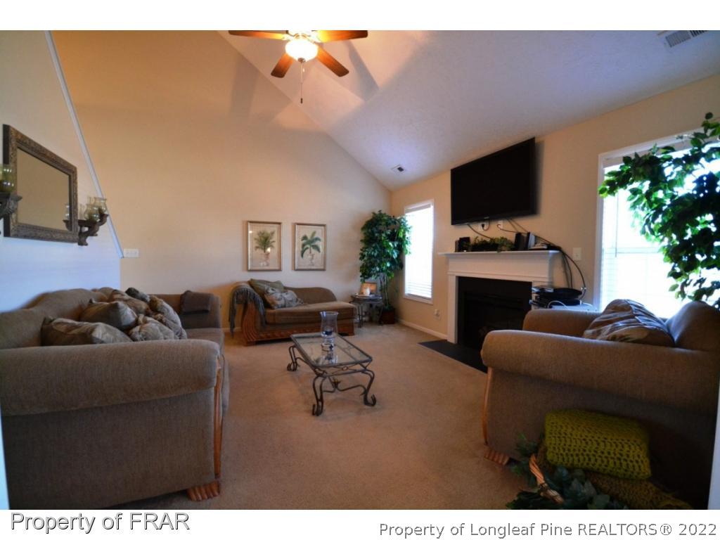 645 Cape Fear Road Raeford, NC 28376 - Photo 7 of 24 a living room with furniture a flat screen tv and a fireplace