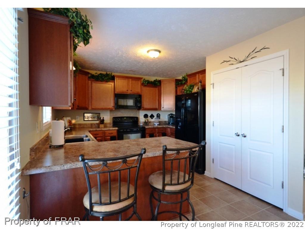 645 Cape Fear Road Raeford, NC 28376 - Photo 9 of 24 a kitchen with a refrigerator and a stove top oven