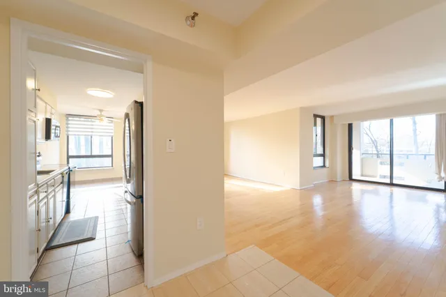 a view of a hallway with wooden floor and a bathroom
