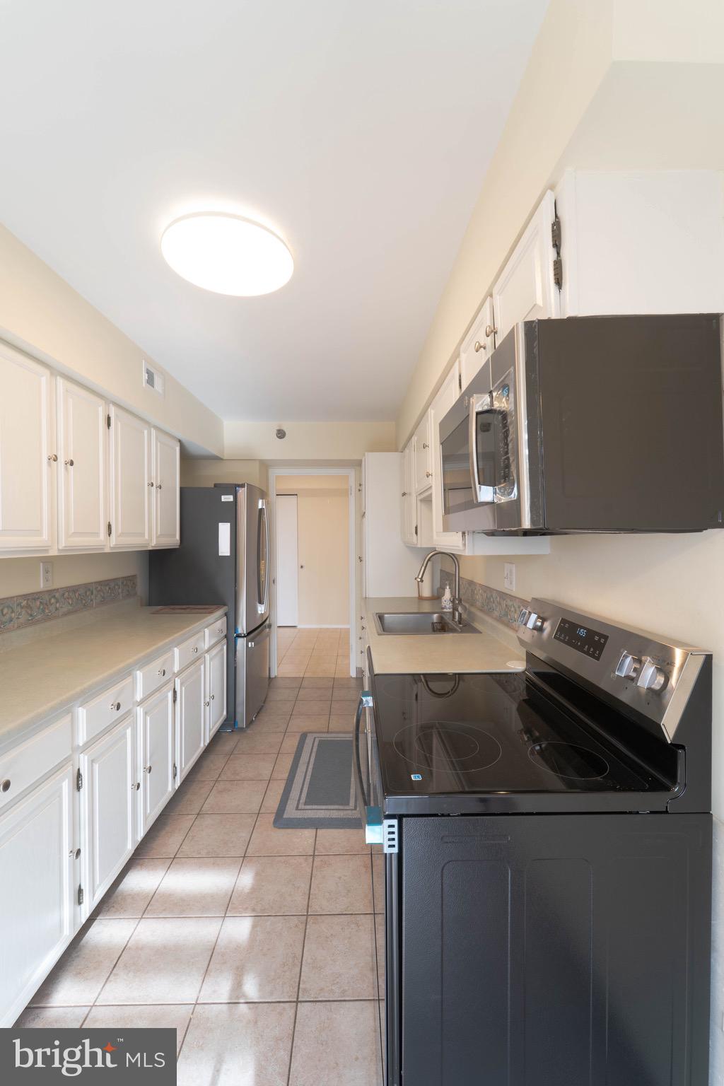1808 Old Meadow Road, Unit 805 McLean, VA 22102 - Photo 4 of 58 a kitchen that has a sink and a stove