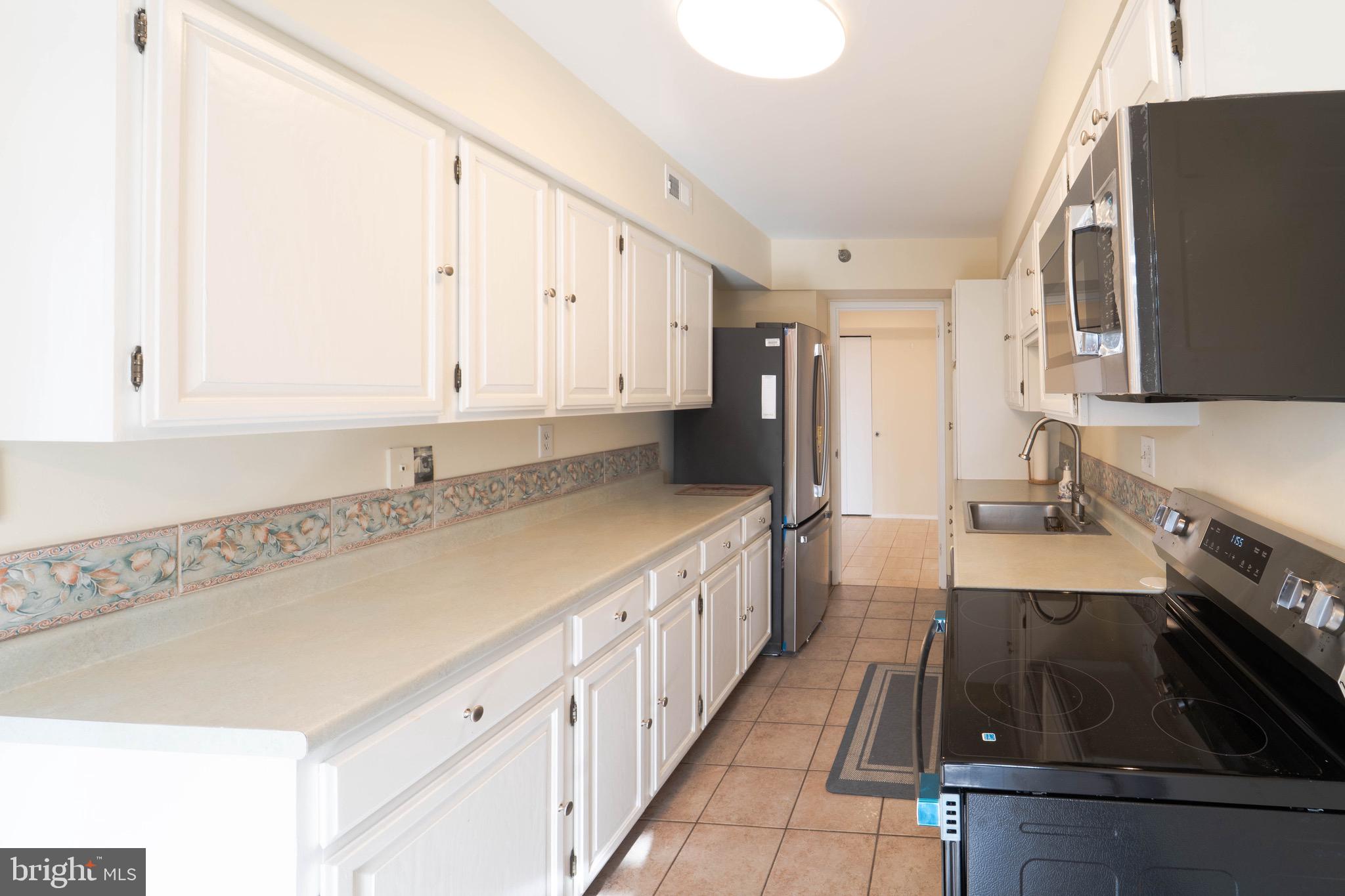 1808 Old Meadow Road, Unit 805 McLean, VA 22102 - Photo 5 of 58 a kitchen with granite countertop a sink stove and refrigerator