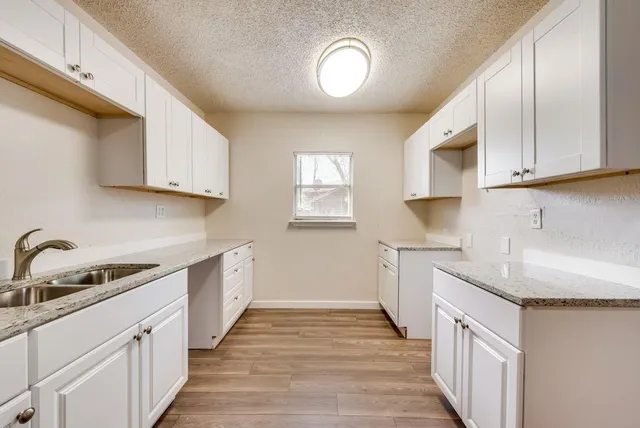 a kitchen with cabinets appliances a sink and a counter top space