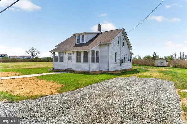 a view of a house with a yard and a large tree