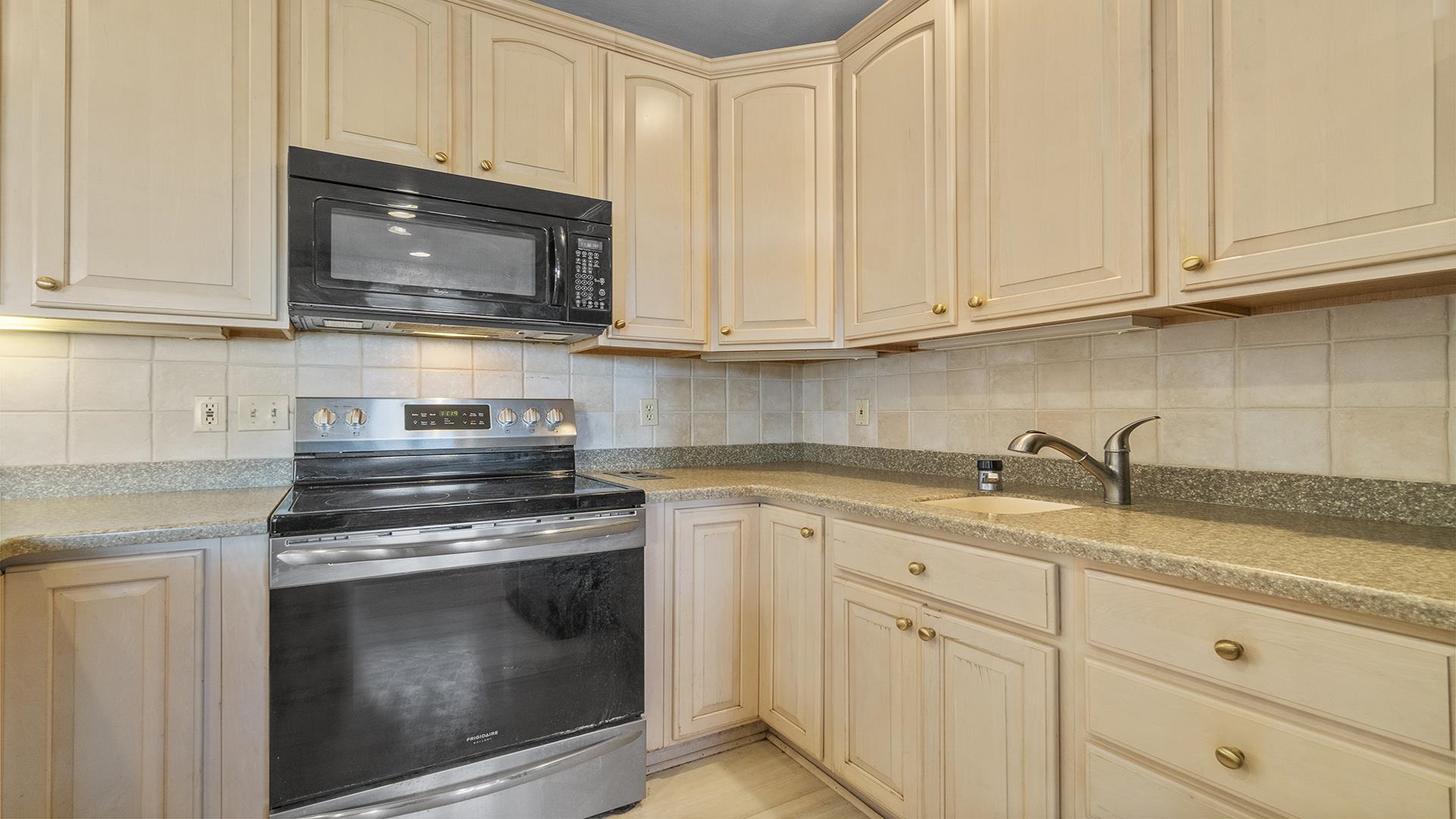 7674 West Pines Road Polo, IL 61064 - Photo 11 of 60 a kitchen with granite countertop white cabinets stainless steel appliances and sink