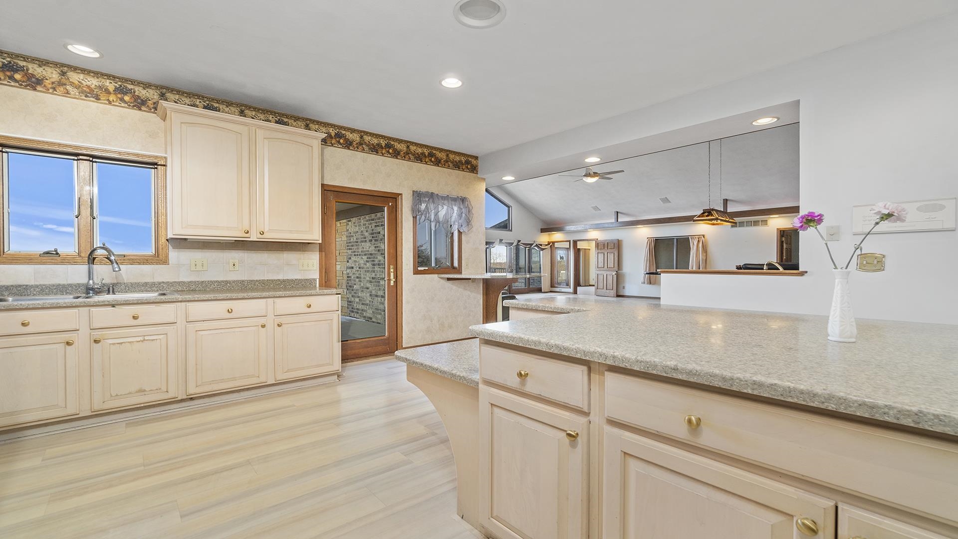 7674 West Pines Road Polo, IL 61064 - Photo 12 of 60 a kitchen with stainless steel appliances granite countertop a sink dishwasher and white cabinets with wooden floor