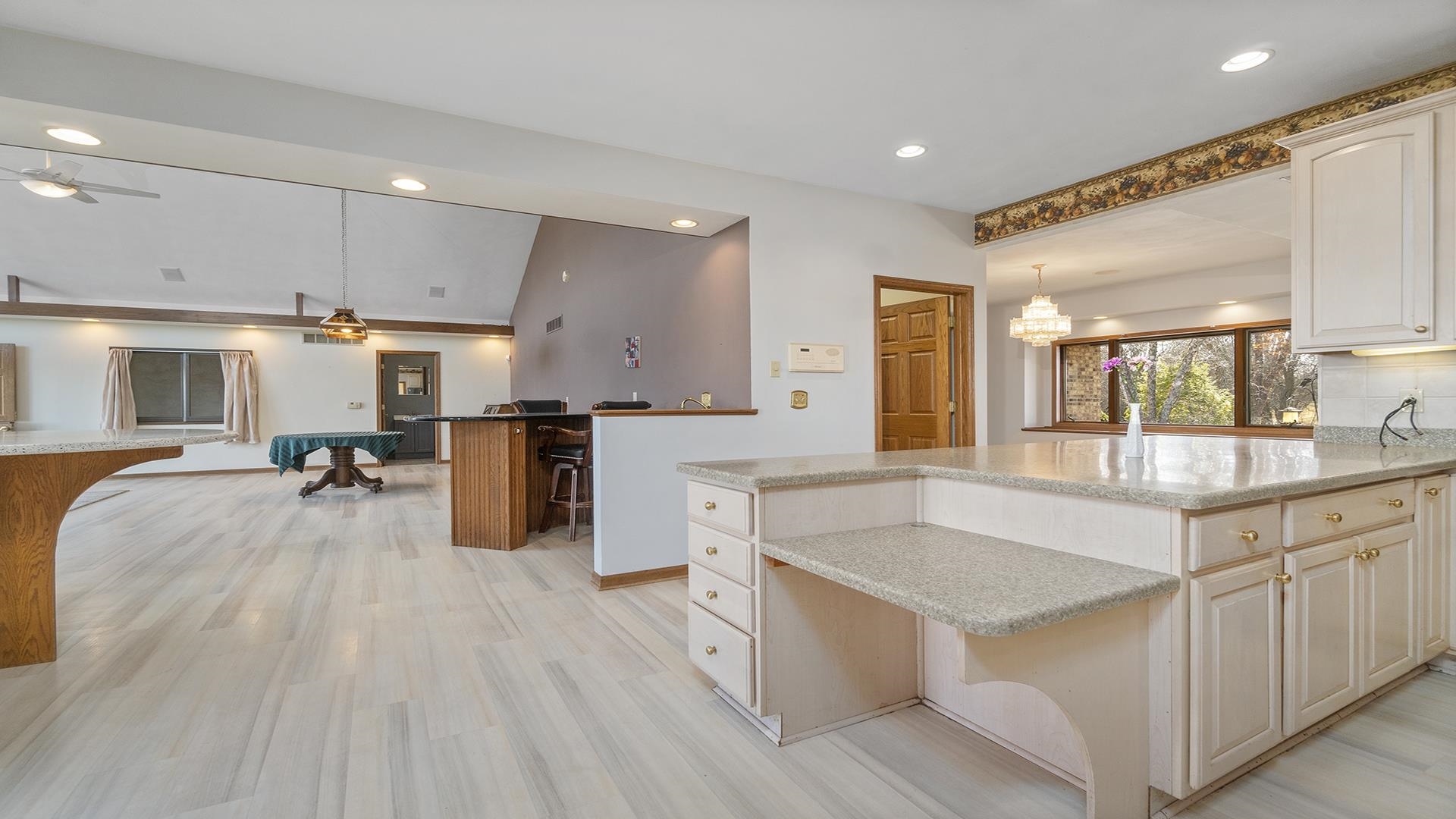 7674 West Pines Road Polo, IL 61064 - Photo 13 of 60 a large kitchen with stainless steel appliances granite countertop a lot of counter space and wooden floors