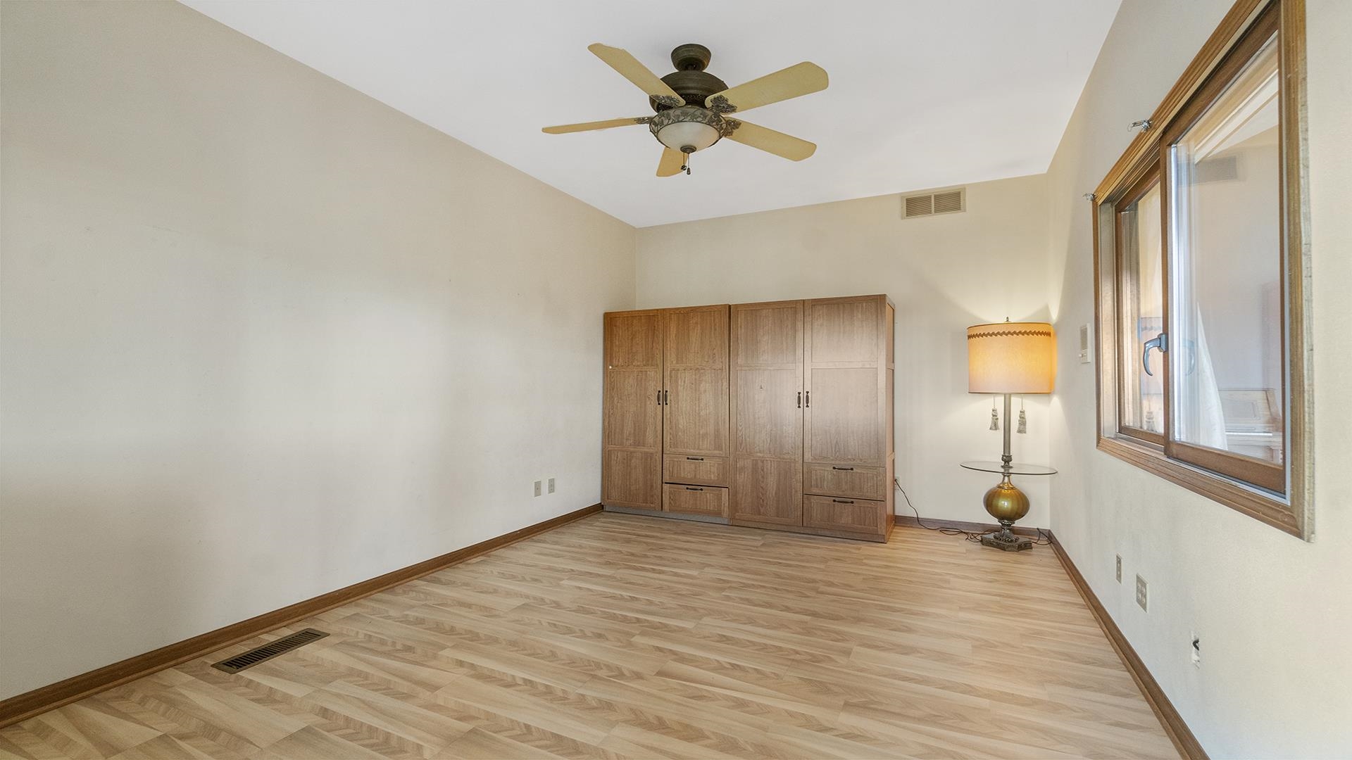 7674 West Pines Road Polo, IL 61064 - Photo 19 of 60 a view of a livingroom with wooden floor and a ceiling fan