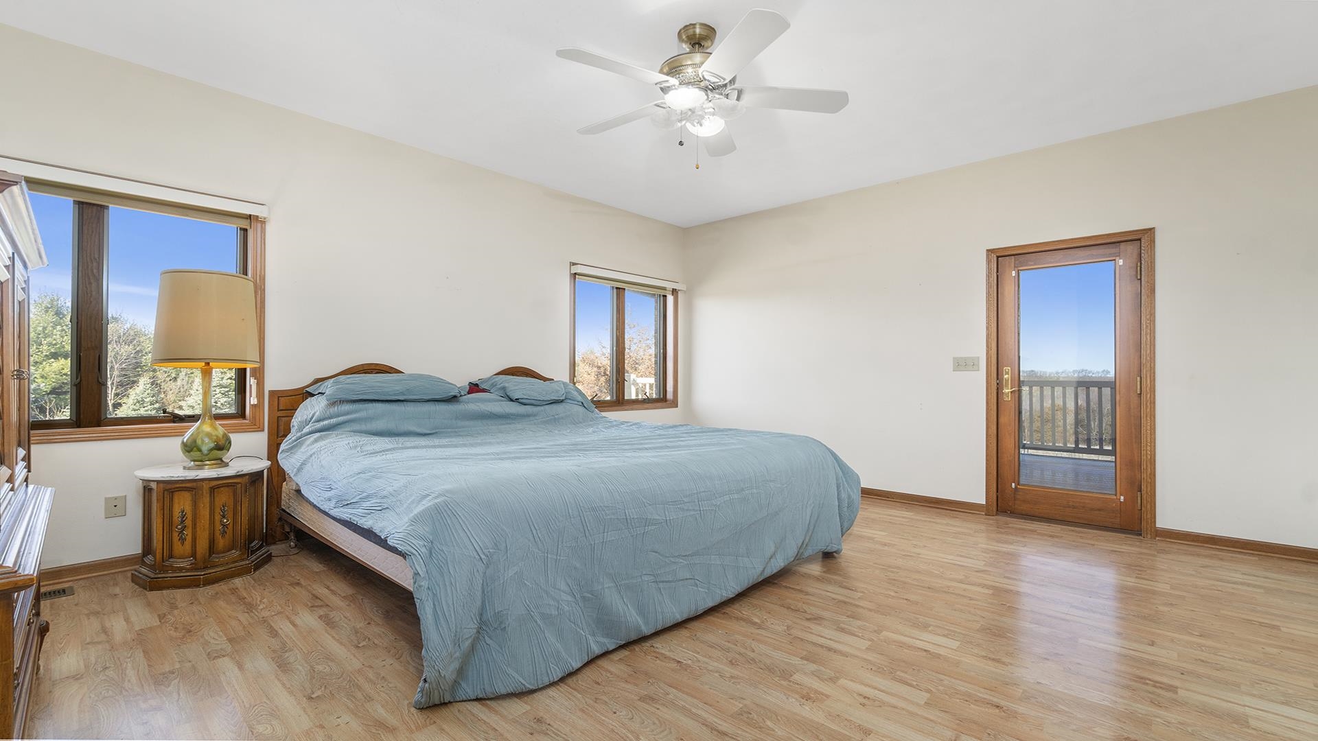 7674 West Pines Road Polo, IL 61064 - Photo 31 of 60 a spacious bedroom with a bed and a chandelier