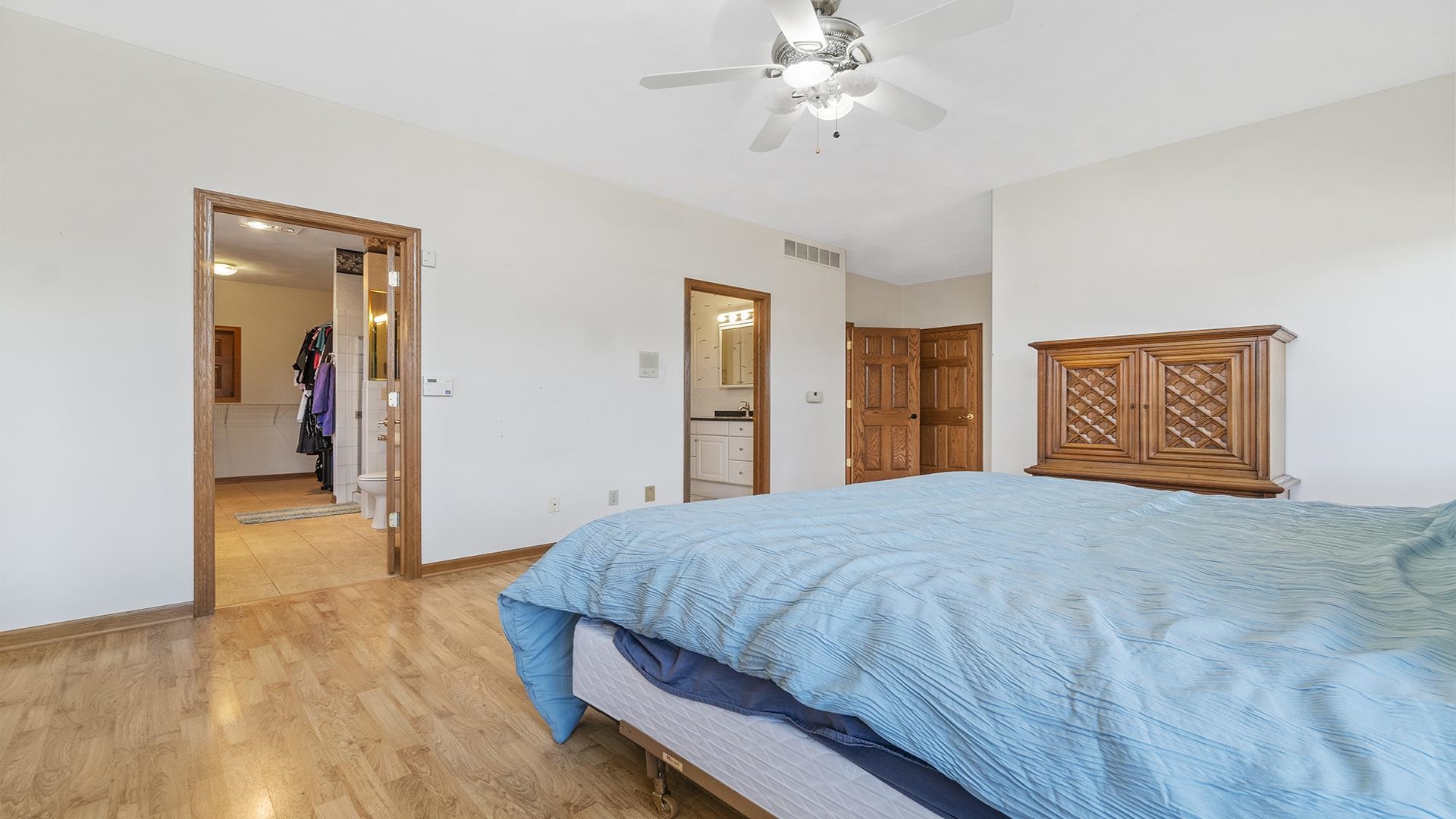 7674 West Pines Road Polo, IL 61064 - Photo 33 of 60 a bedroom with a large bed and a chandelier