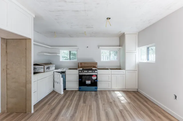 a kitchen with granite countertop a refrigerator stove top oven and sink