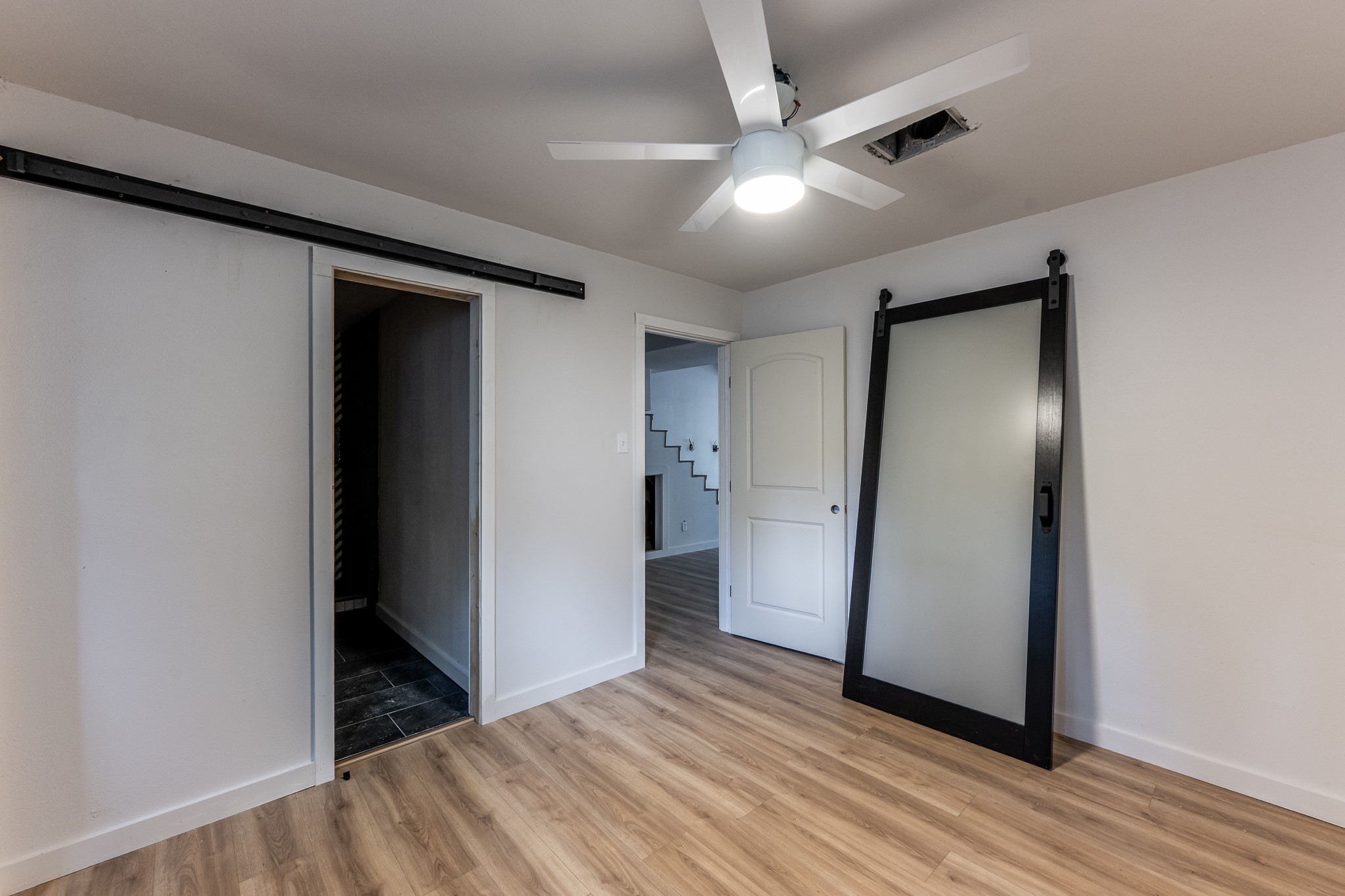 28600 Rantoul Court Point Blank, TX 77364 - Photo 20 of 33 an empty room with wooden floor and a ceiling fan