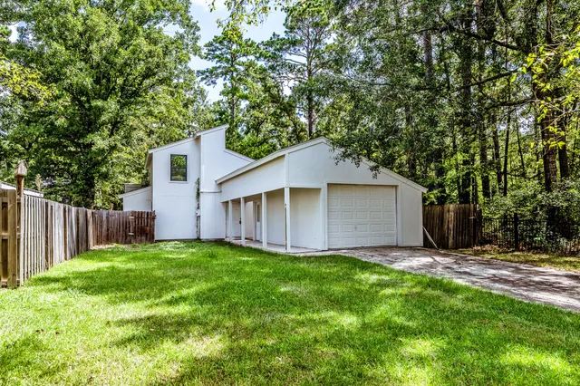 a view of a backyard with a small cabin and wooden fence