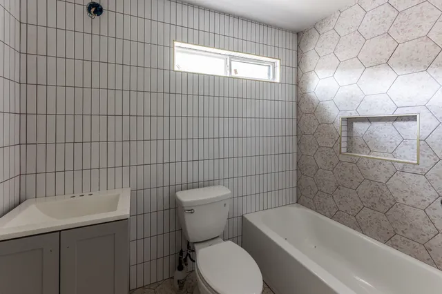 a white toilet sitting next to a bath tub