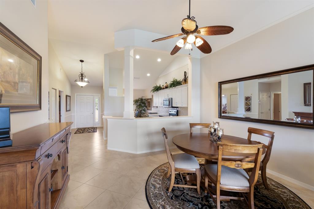 7179 Boca Grove Place, Unit 202 Lakewood Ranch, FL 34202 - Photo 12 of 46 a view of a dining room with furniture and a chandelier