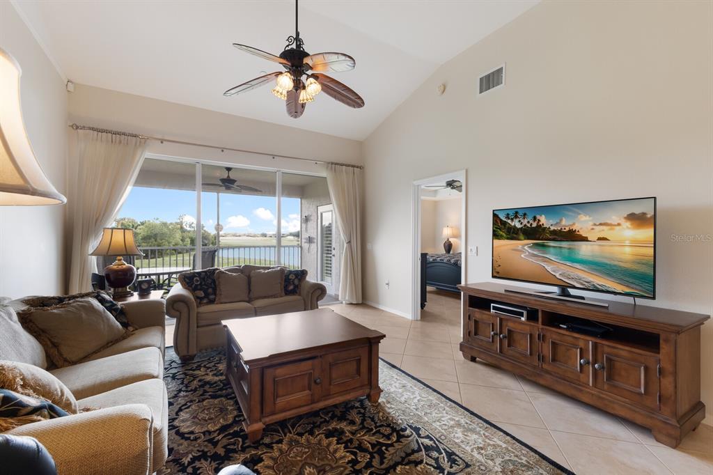 7179 Boca Grove Place, Unit 202 Lakewood Ranch, FL 34202 - Photo 14 of 46 a living room with furniture and a flat screen tv