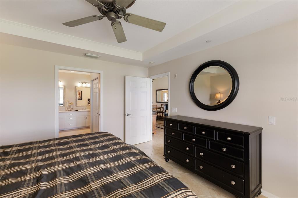 7179 Boca Grove Place, Unit 202 Lakewood Ranch, FL 34202 - Photo 24 of 46 a bedroom with a bed and a chandelier