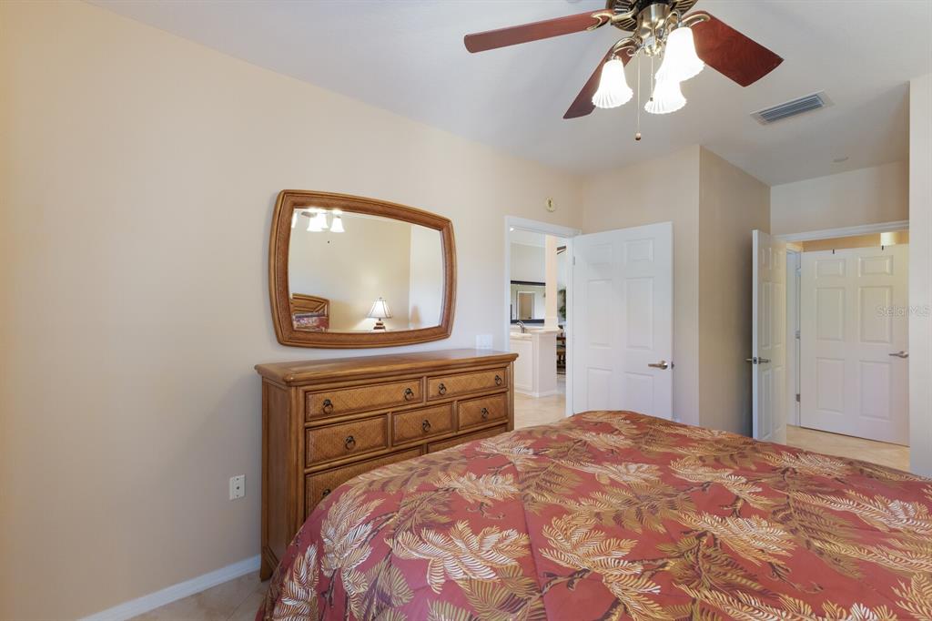 7179 Boca Grove Place, Unit 202 Lakewood Ranch, FL 34202 - Photo 26 of 46 a bedroom with a bed and a dresser