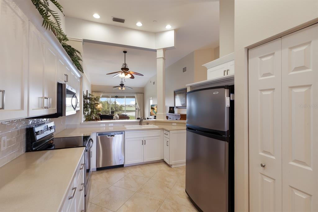 7179 Boca Grove Place, Unit 202 Lakewood Ranch, FL 34202 - Photo 8 of 46 a kitchen with refrigerator and cabinets