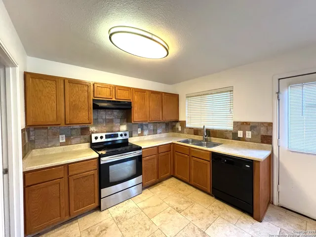 a kitchen with stainless steel appliances granite countertop a sink stove and cabinets