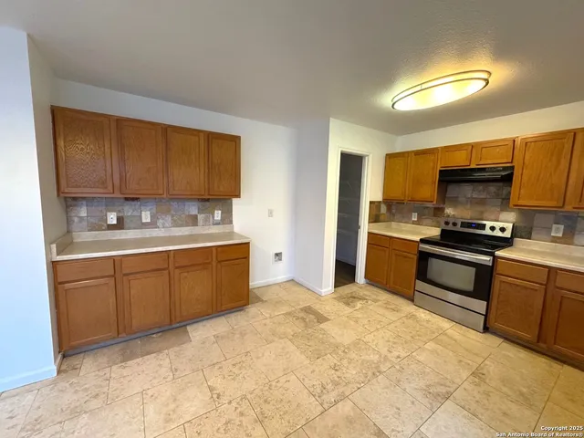 a kitchen with stainless steel appliances granite countertop a stove a sink dishwasher and a refrigerator