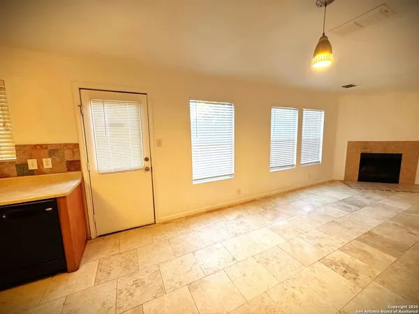 a view of an empty room with window and cabinet