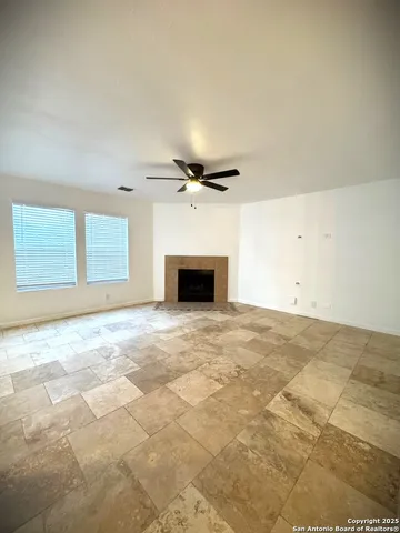 an empty room with a ceiling fan and window