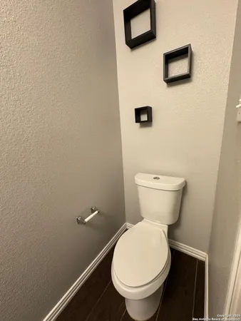 a white toilet sitting next to a white wall