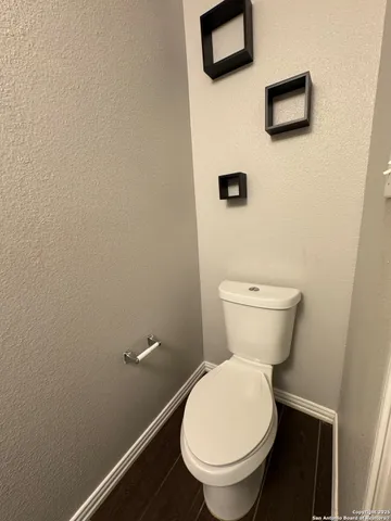 a white toilet sitting next to a white wall
