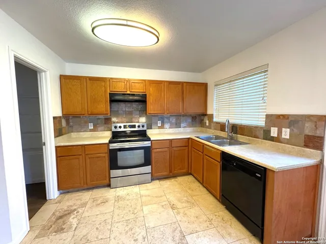 a kitchen with a stove a sink and a refrigerator