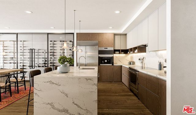 a large kitchen with kitchen island a large window a sink and stainless steel appliances