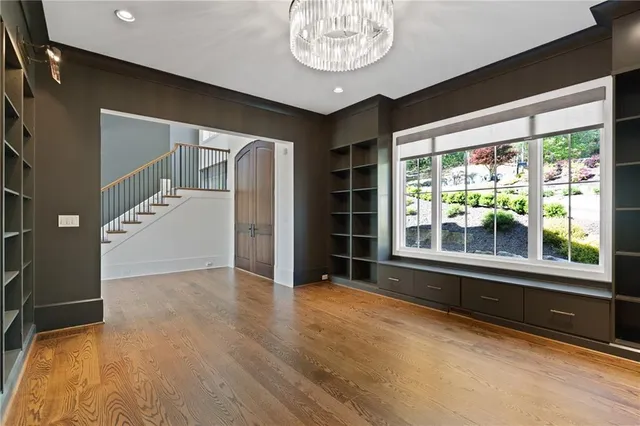 a view of hallway with a large window and wooden floor