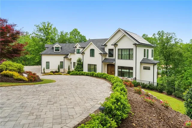 a front view of a house with yard and green space