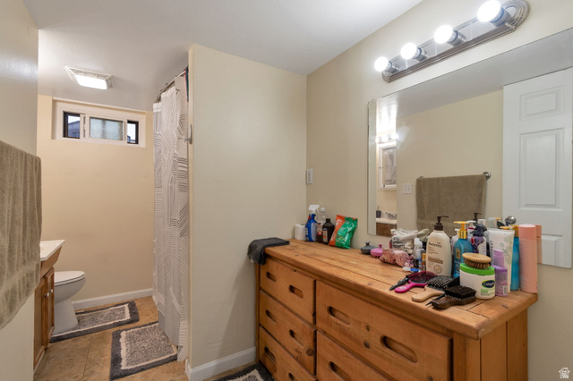 7466 Washington Road Magna, UT 84044 - Photo 17 of 21 Bathroom with vanity lighting, large wall mirror, and a shower with a patterned curtain