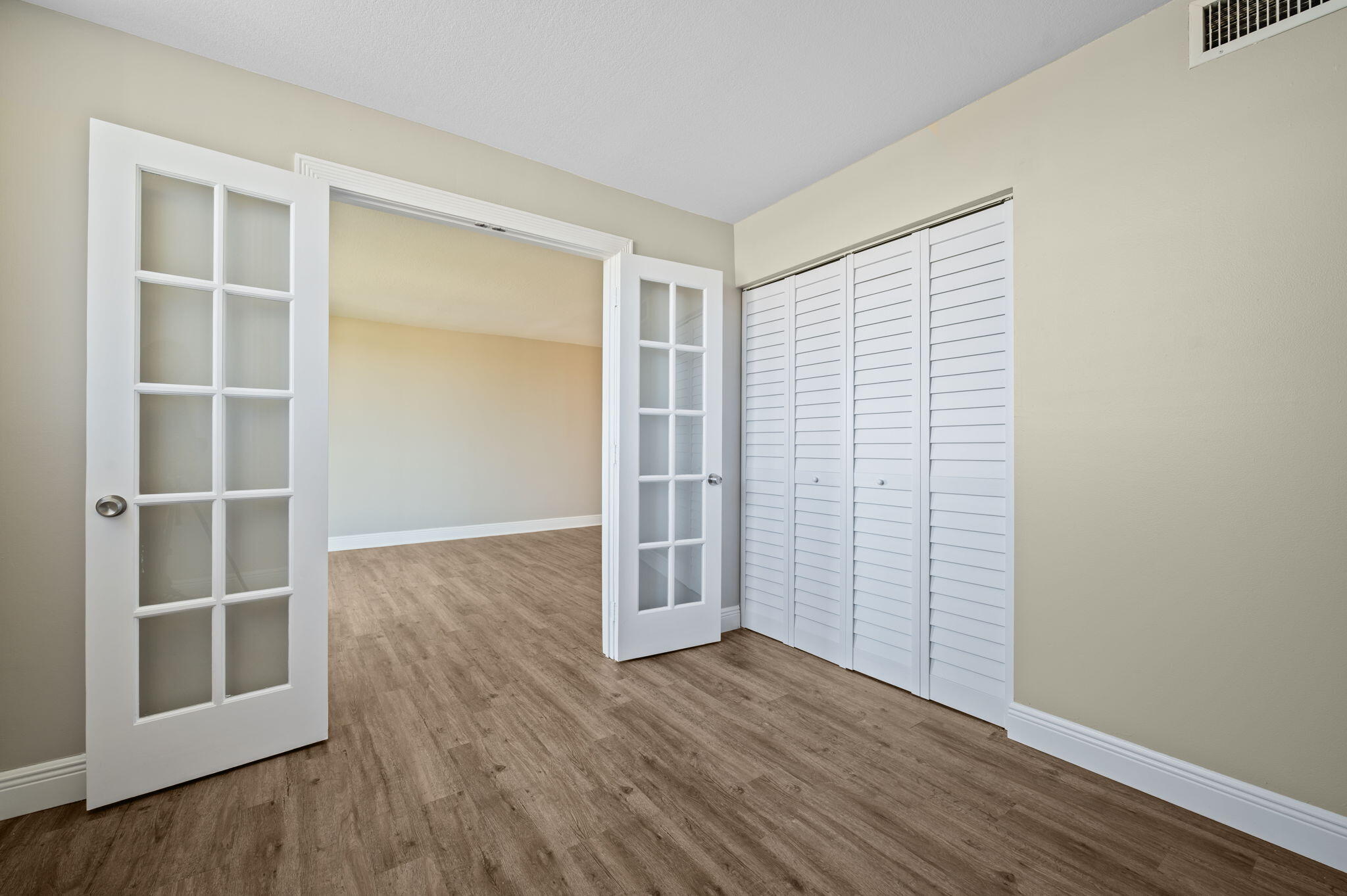 5700 Northwest 2nd Avenue, Unit 410 Boca Raton, FL 33487 - Photo 17 of 34 an empty room with wooden floor and windows