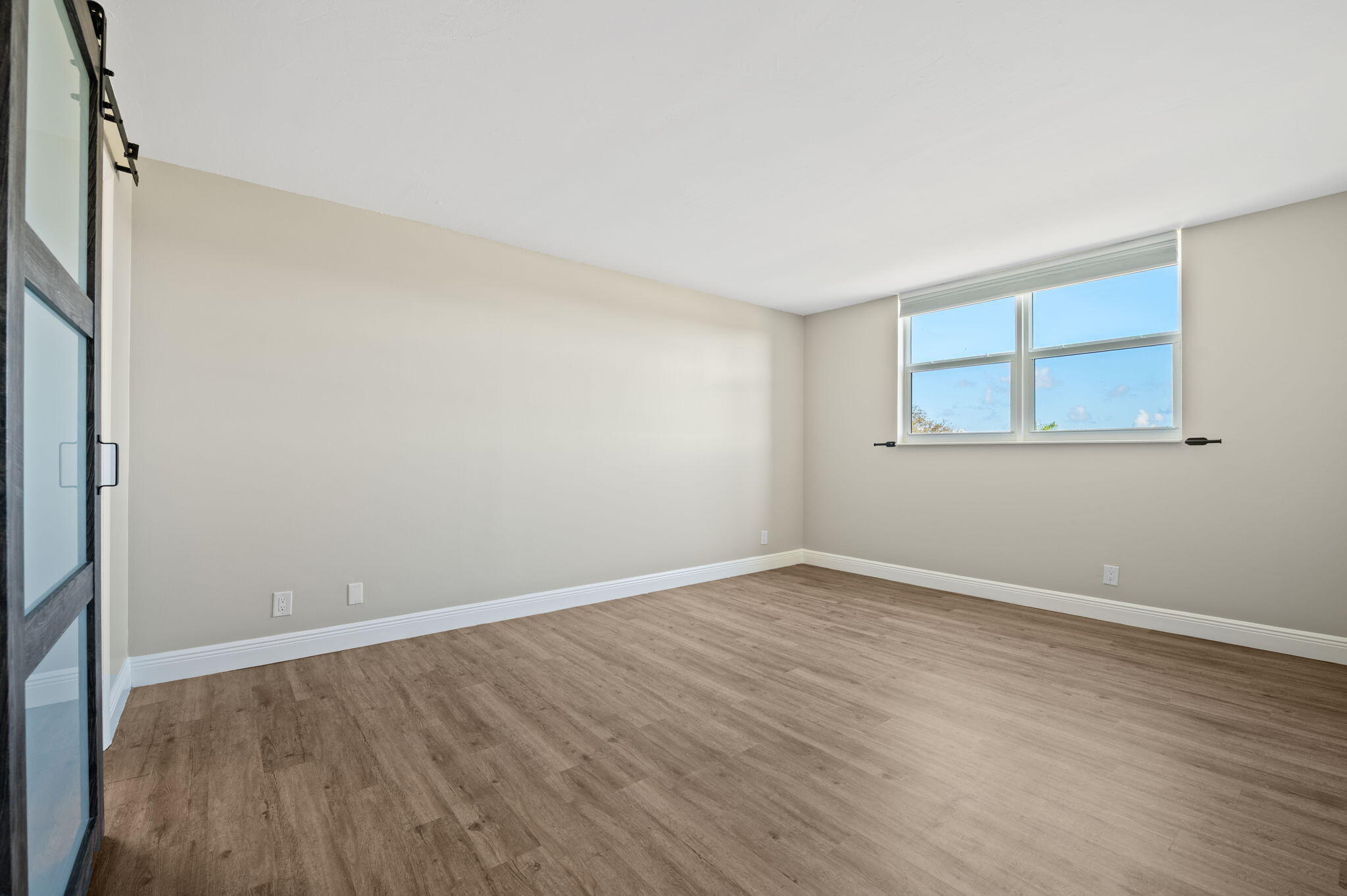 5700 Northwest 2nd Avenue, Unit 410 Boca Raton, FL 33487 - Photo 19 of 34 a view of an empty room with wooden floor and a window