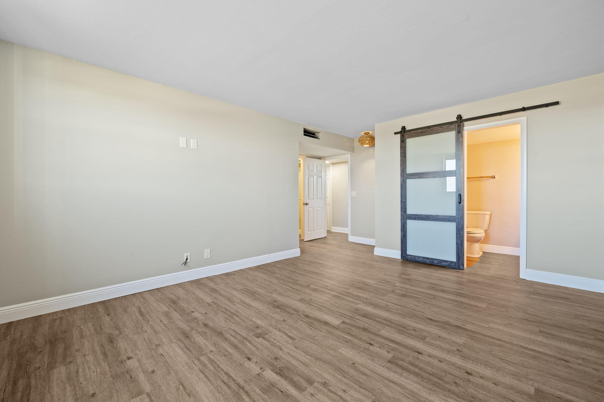 5700 Northwest 2nd Avenue, Unit 410 Boca Raton, FL 33487 - Photo 20 of 34 a view of an empty room with wooden floor and a window
