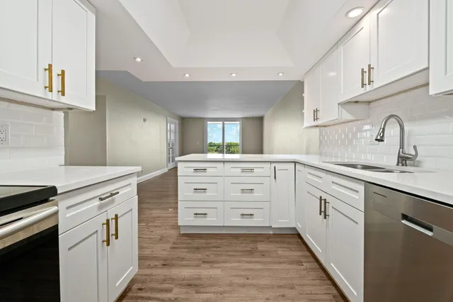 a kitchen with white cabinets and appliances