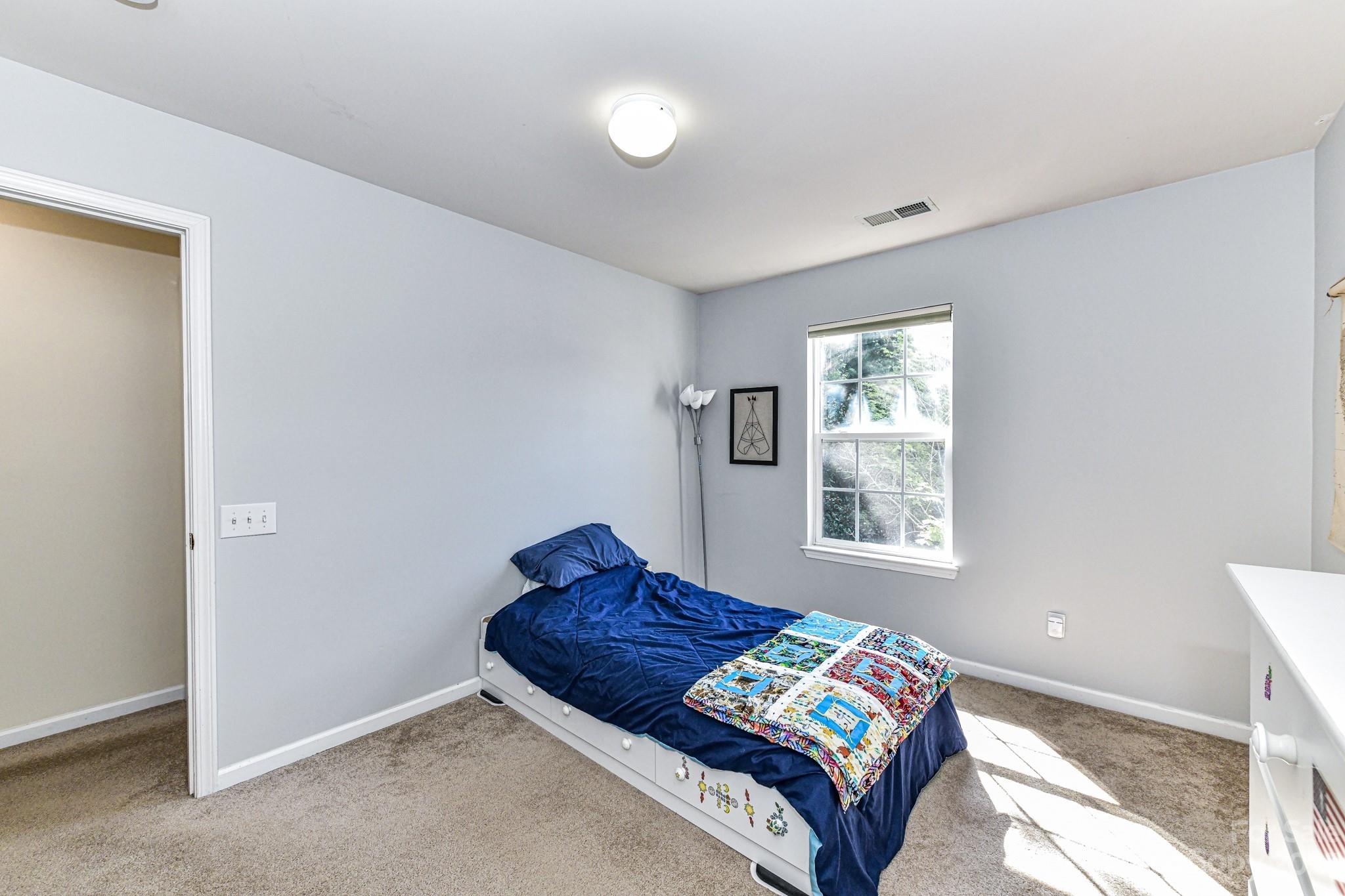 6991 Rothchild Drive Charlotte, NC 28270 - Photo 23 of 37 a bed sitting in a bedroom next to a window