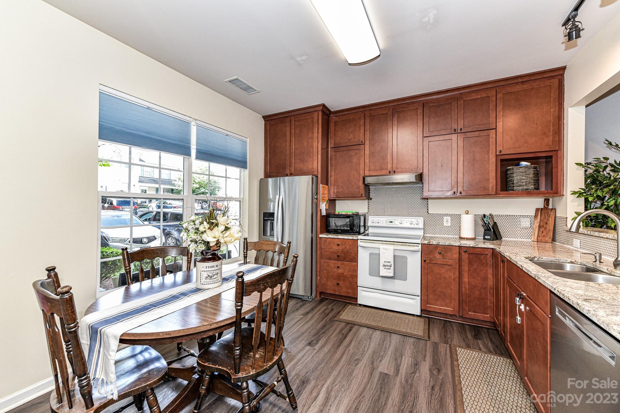 6991 Rothchild Drive Charlotte, NC 28270 - Photo 5 of 37 a kitchen with stainless steel appliances wooden floors and wooden cabinets